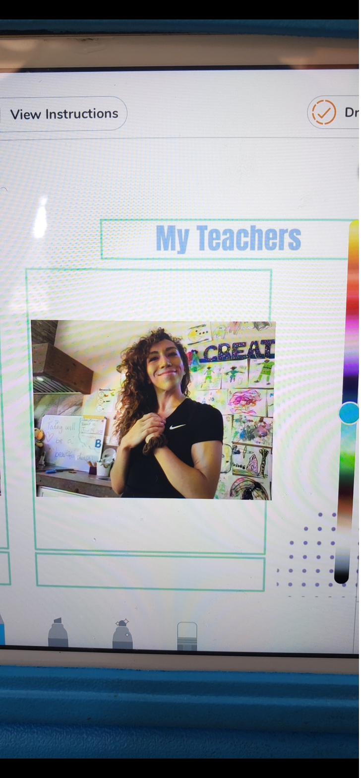 Dora in her pandemic-era classroom, surrounded by children's artwork